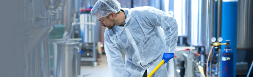 Mann bei der Reinigung einer Maschine